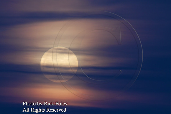 Full Moon Rising Through Thin Veil of Clouds